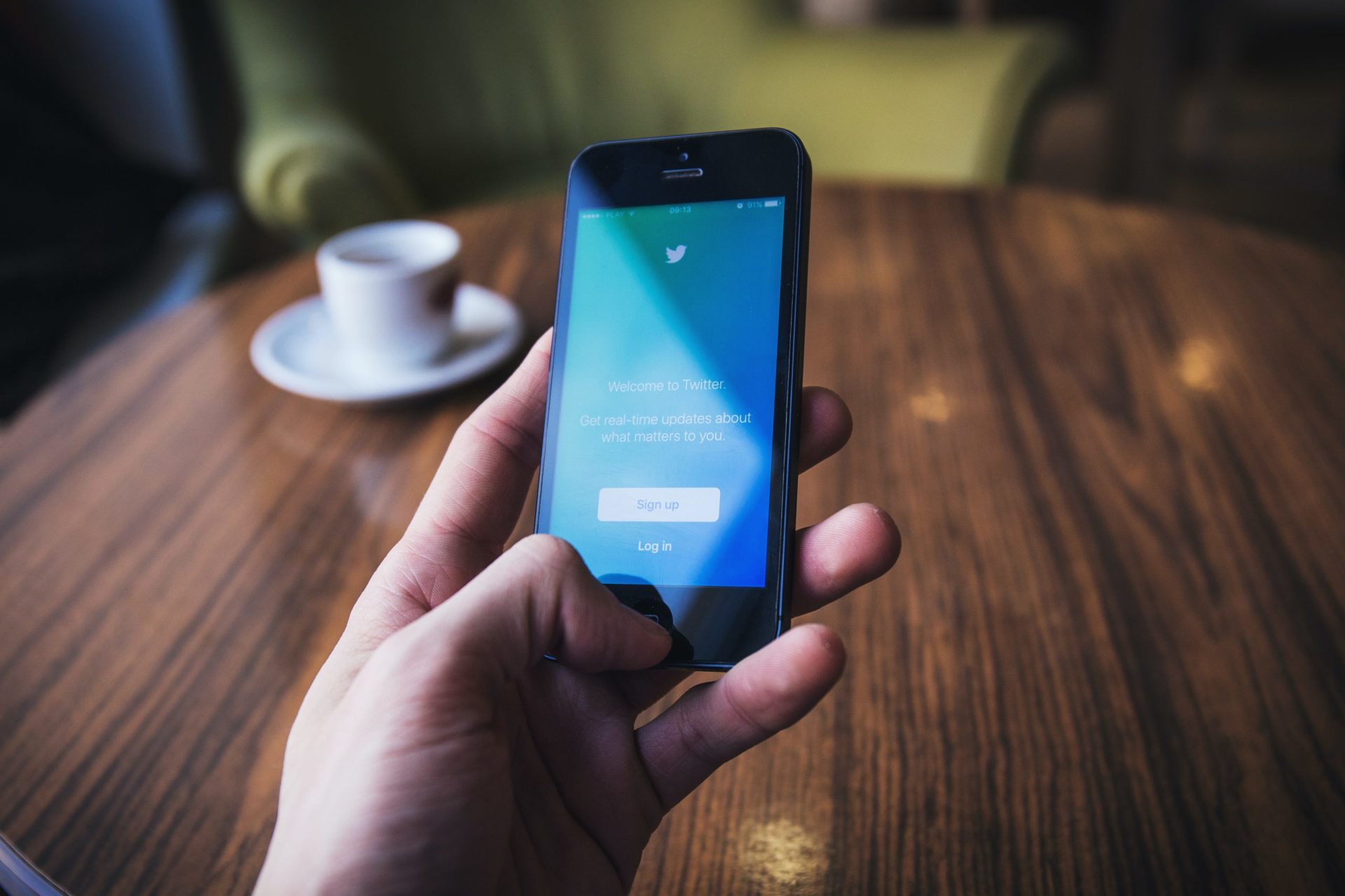 person holding a phone with twitter